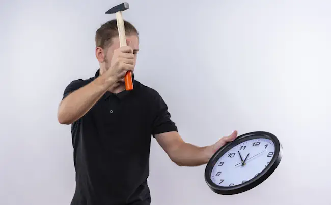 man met een hamer wil een klok kapot slaan