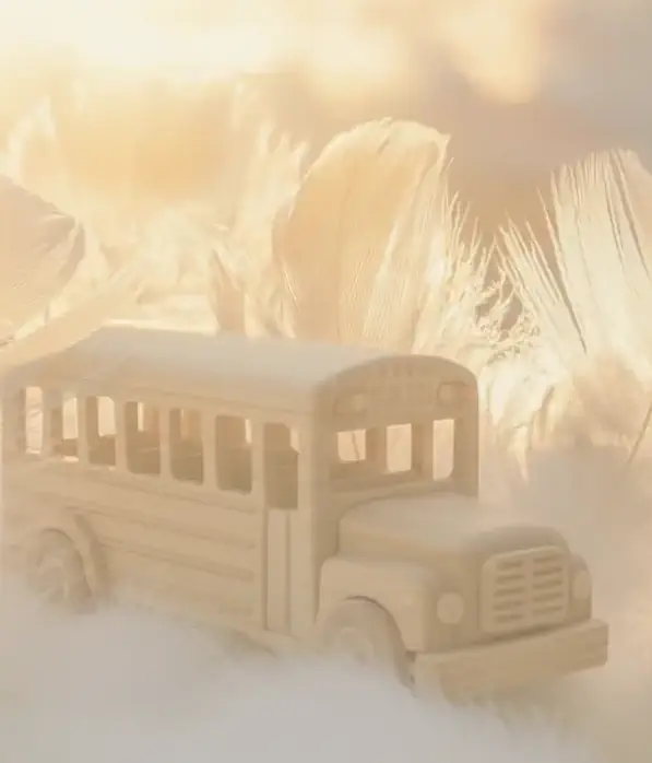 Houten bus tussen veren in warm licht, symbool voor Voice Dialogue en innerlijke stemmen